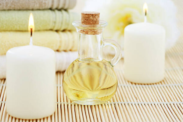 Massage oil with candles and towels beauty treatment