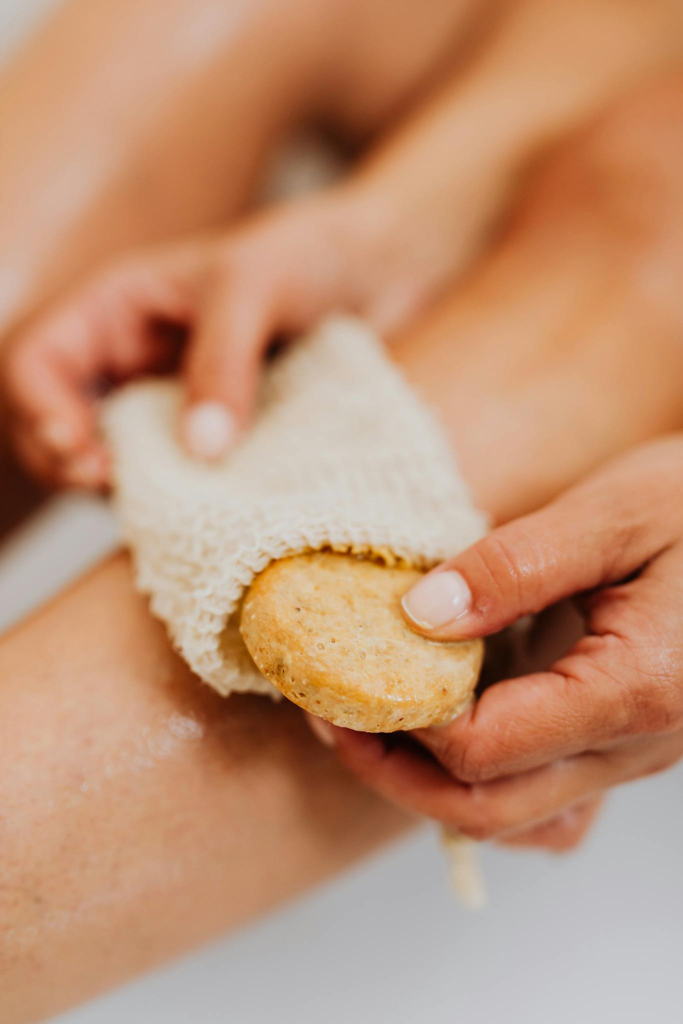 Up-close view of exfoliating bath sponge being used for skincare and wellness.
